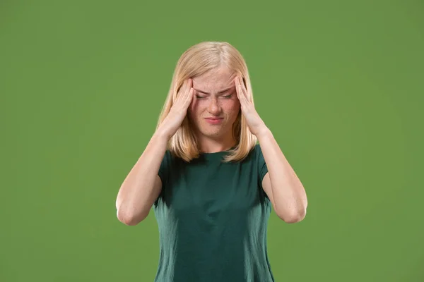 Kvinna att ha huvudvärk. Isolerade över grön bakgrund. — Stockfoto