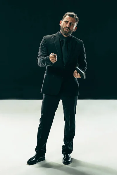 Concepto de belleza masculino. Retrato de un joven de moda con corte de pelo elegante con traje de moda posando sobre fondo negro . —  Fotos de Stock