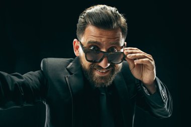 Siyah stüdyoda elbiseli barded adam