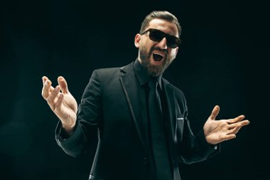 Siyah stüdyoda elbiseli barded adam