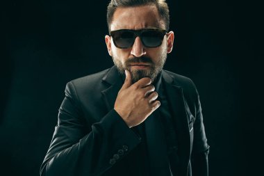 Siyah stüdyoda elbiseli barded adam