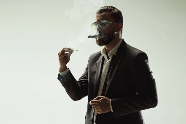 Бардаючий чоловік у костюмі тримає сигару — стокове фото