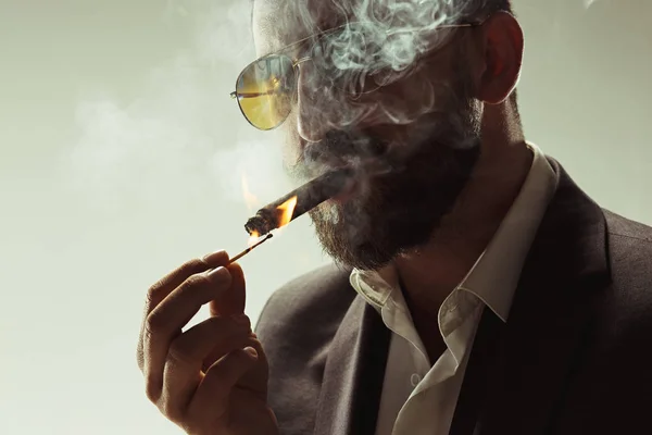 El hombre barbudo con un traje sosteniendo cigarros — Foto de Stock