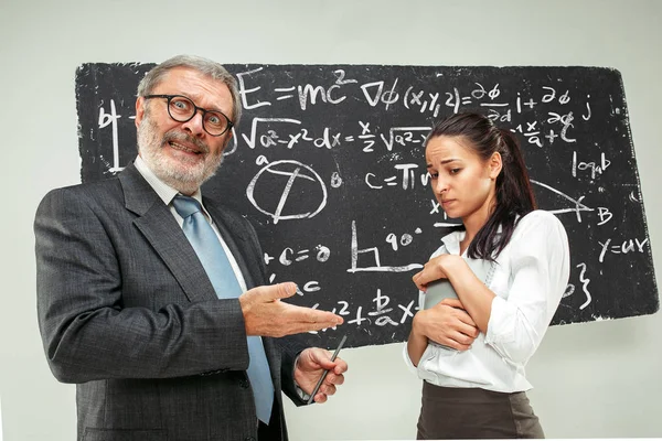 Profesor y joven contra pizarra en el aula — Foto de Stock