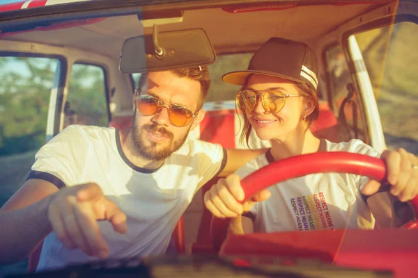 Rindo casal romântico sentado no carro, enquanto fora em uma viagem de carro no dia de verão — Fotografia de Stock