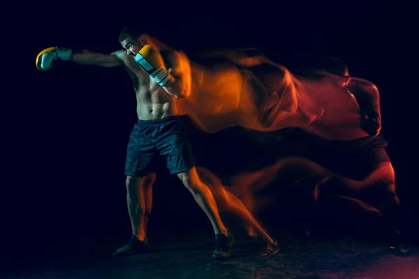 Boxer maschile boxe in uno studio buio — Foto Stock