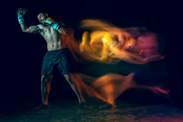 Boxer maschile boxe in uno studio buio — Foto Stock