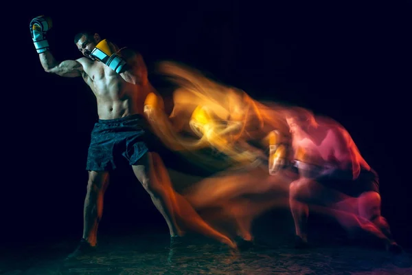 Boxer masculino boxe em um estúdio escuro — Fotografia de Stock