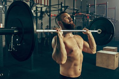 Genç adam bir spor salonunda egzersiz Barbell kaldırma uygun