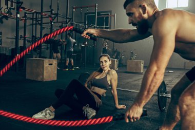 Savaş ip savaş ipleri egzersiz fitness salonunda erkeklerle.