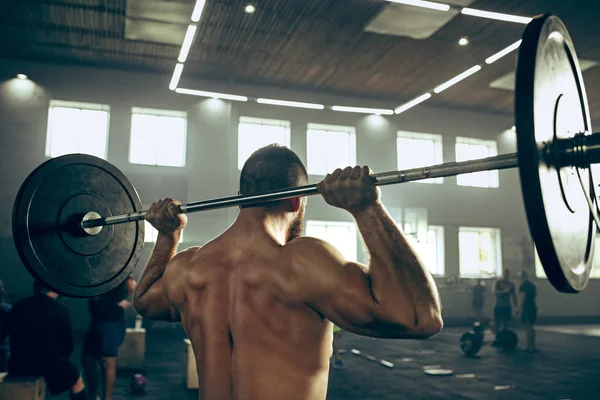 Fit jonge man tillen halters trainen in een sportschool — Stockfoto