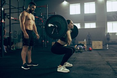 Uygun genç kadın bir spor salonunda egzersiz barbell kaldırma