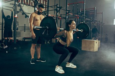 Uygun genç kadın bir spor salonunda egzersiz barbell kaldırma