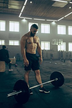 Genç adam bir spor salonunda egzersiz Barbell kaldırma uygun