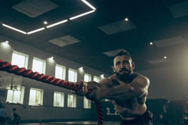 Savaş ip savaş ipleri egzersiz fitness salonunda erkeklerle.