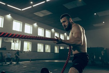 Savaş ip savaş ipleri egzersiz fitness salonunda erkeklerle.