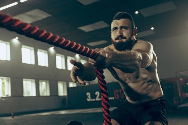Savaş ip savaş ipleri egzersiz fitness salonunda erkeklerle.