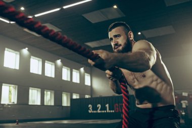 Savaş ip savaş ipleri egzersiz fitness salonunda erkeklerle.