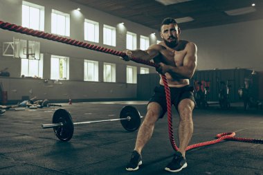 Savaş ip savaş ipleri egzersiz fitness salonunda erkeklerle.