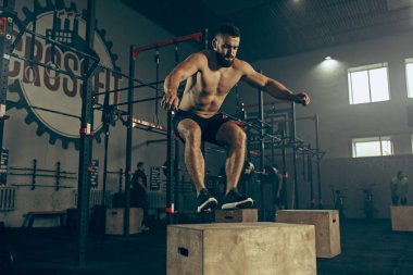 Fitness salonunda egzersiz sırasında atlama adam. CrossFit.