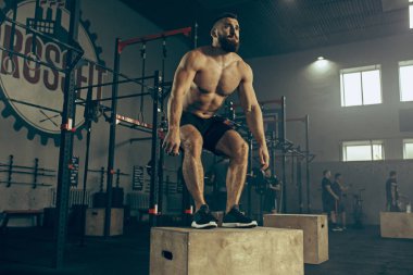 Fitness salonunda egzersiz sırasında atlama adam. CrossFit.