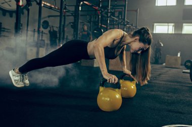 Uygun genç kadın bir spor salonunda egzersiz barbell kaldırma