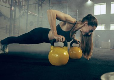Uygun genç kadın bir spor salonunda egzersiz barbell kaldırma