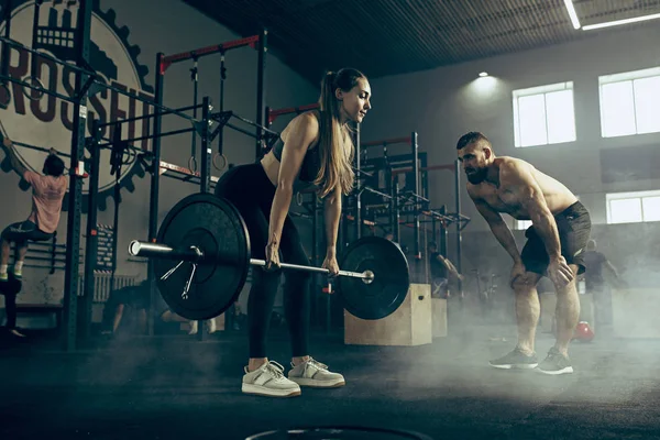 Alkalmas fiatal nő emelő barbells dolgozott ki egy tornaterem — Stock Fotó