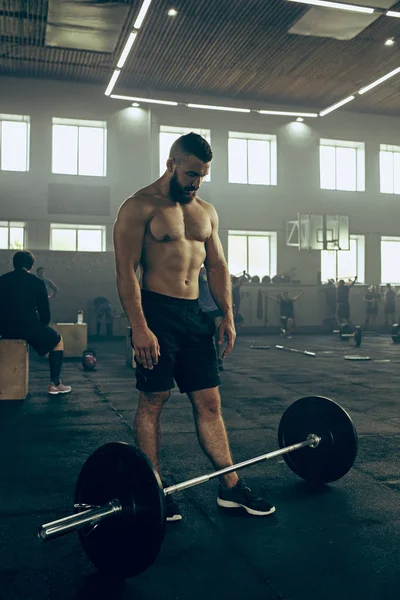 Genç adam bir spor salonunda egzersiz Barbell kaldırma uygun — Stok fotoğraf