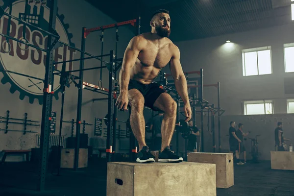 Fitness salonunda egzersiz sırasında atlama adam. CrossFit.