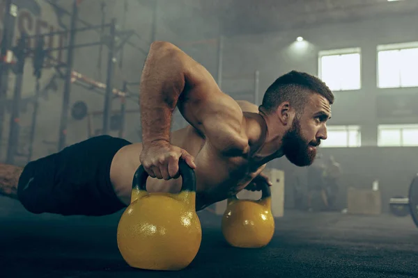 Ajuste joven levantando barras de entrenamiento en un gimnasio — Foto de Stock