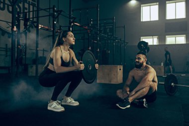 Uygun genç kadın bir spor salonunda egzersiz barbell kaldırma