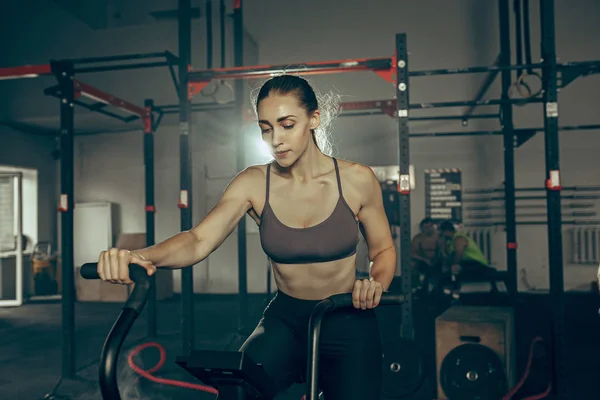 Vrouw tijdens oefeningen in de fitnessruimte. CrossFit. — Stockfoto