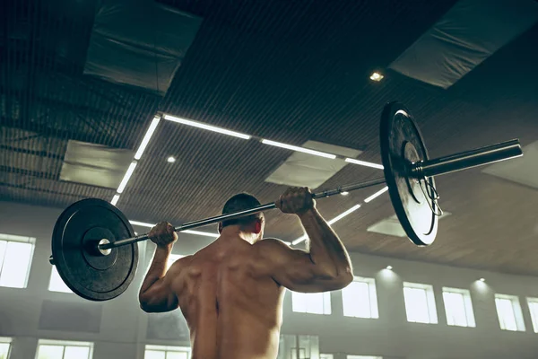 Вмістити молодого чоловіка, який піднімає штанги, що працюють у спортзалі — стокове фото