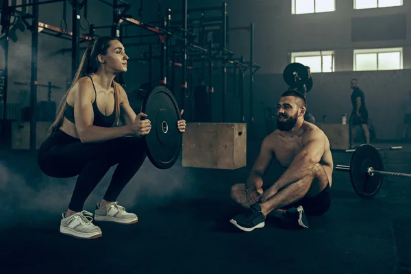 Ajuste mujer joven levantando barras de ejercicio en un gimnasio — Foto de Stock