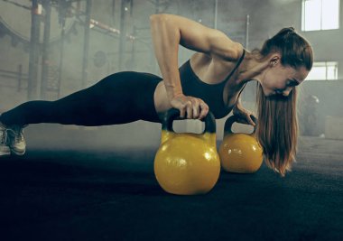Uygun genç kadın bir spor salonunda egzersiz barbell kaldırma