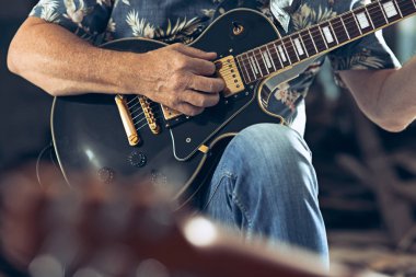 Rock müzik grubu tekrarı. Elektro gitar çalar ve davulcu arkasında davul seti.