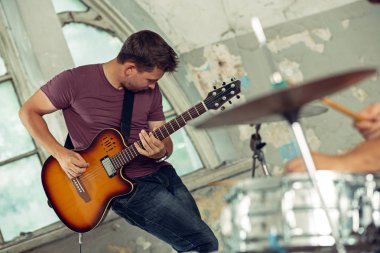 Rock müzik grubu tekrarı. Bas gitarist, elektro gitar çalar ve çatı, davulcu. Rock müzik ve reçel oturum kavramı. tutku müzik ve gençlik kültürü kavramları