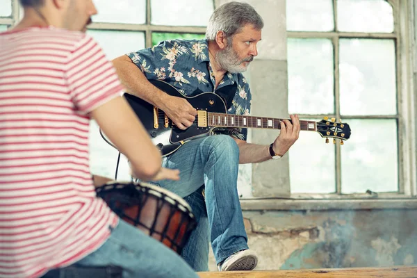 Herhaling van rock muziekband. Elektrische gitarist en drummer achter het drumstel. — Stockfoto