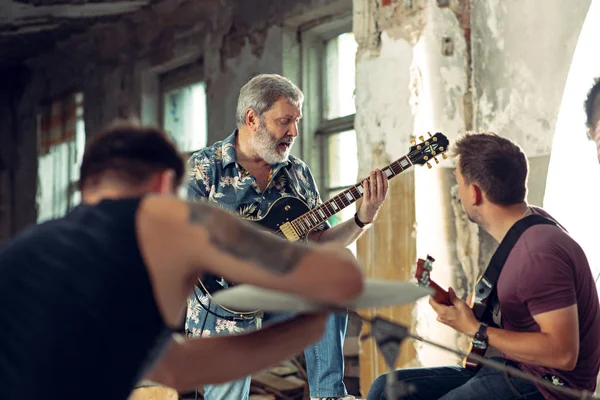 Herhaling van rock muziekband. Elektrische gitarist en drummer achter het drumstel. — Stockfoto