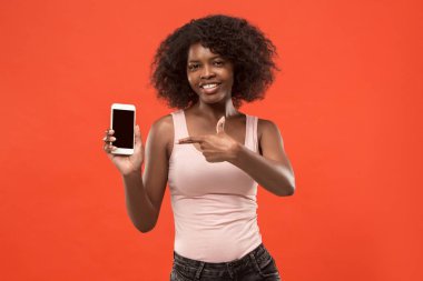 Boş ekran cep telefonu izole kırmızı arka plan üzerinde gösterilen emin casual afro kız portresi