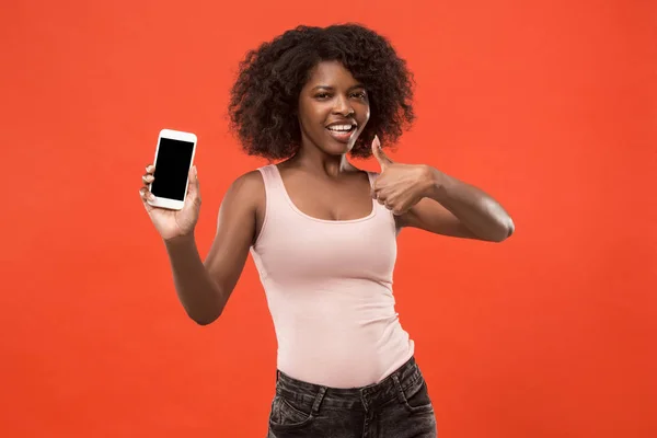 Portrait d'une fille afro décontractée confiante montrant écran vierge téléphone mobile isolé sur fond rouge — Photo