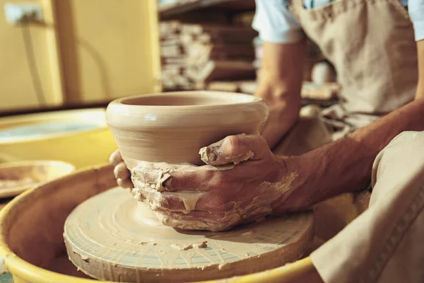 Creating a jar or vase of white clay close-up. Master crock. Man hands making clay jug macro.