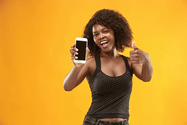 Retrato de una chica afro casual confiada que muestra el teléfono móvil de pantalla en blanco —  Fotos de Stock