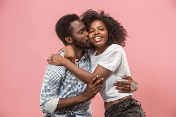 The afro couple watching sports match on tv at home, celebrating victory, successful game. Different emotions concept. Studio shot with african american man and woman