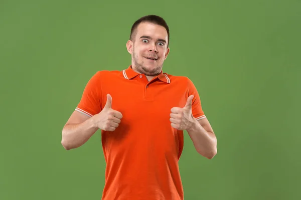 The happy businessman standing and smiling against green background. — Stock Photo, Image