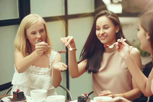 İki kız arkadaş birlikte vakit geçirmek kahvaltı ve tatlı olan kafede kahve içme.