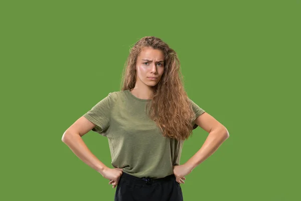 Серйозна бізнес-леді стоїть і дивиться на камеру на зеленому тлі . — стокове фото