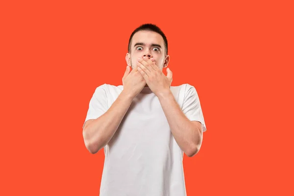 The young man whispering a secret behind her hand over orange background — Stock Photo, Image