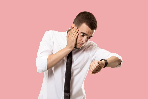 Schöner Geschäftsmann überprüft seine Armbanduhr isoliert auf rosa Hintergrund — Stockfoto